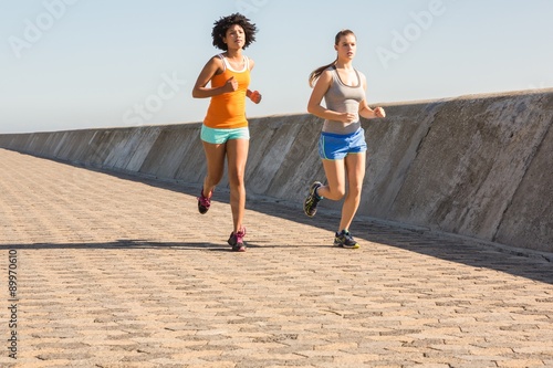 Two young women jogging together