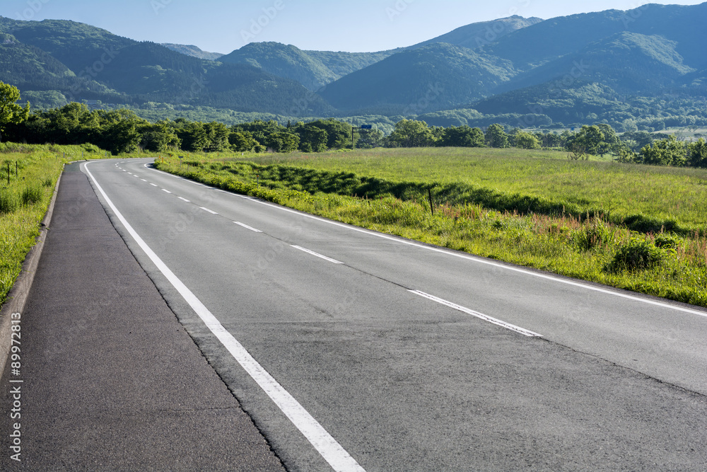 Fototapeta premium Droga na płaskowyżu Senomoto z górami Kuju w tle