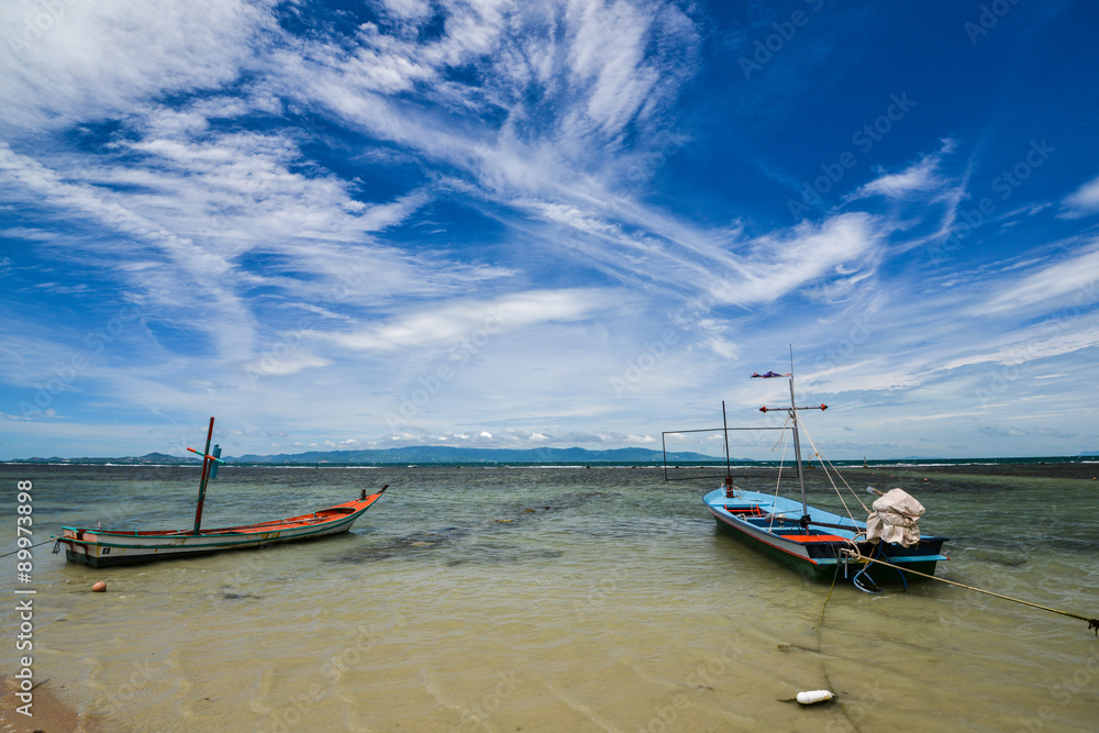 Clear blue sky with cloud and 2 fishing boats in the sea in a shiny day.