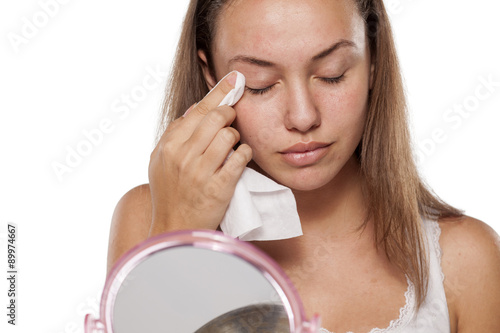 Fotografía young woman cleans her eyelids with wet wipes
