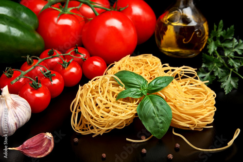Round balls of pasta with tomatoes,basil,olive oil on black