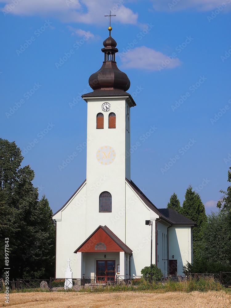 Old rural Catholic church standing on the edge of a field (Sobesovice, Czech Republic).