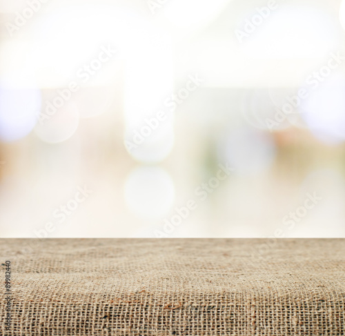 Empty table covered with sackcloth over blurred abstract  photo
