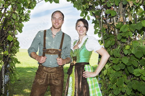 Фотография bavarian couple standing underneath a tree