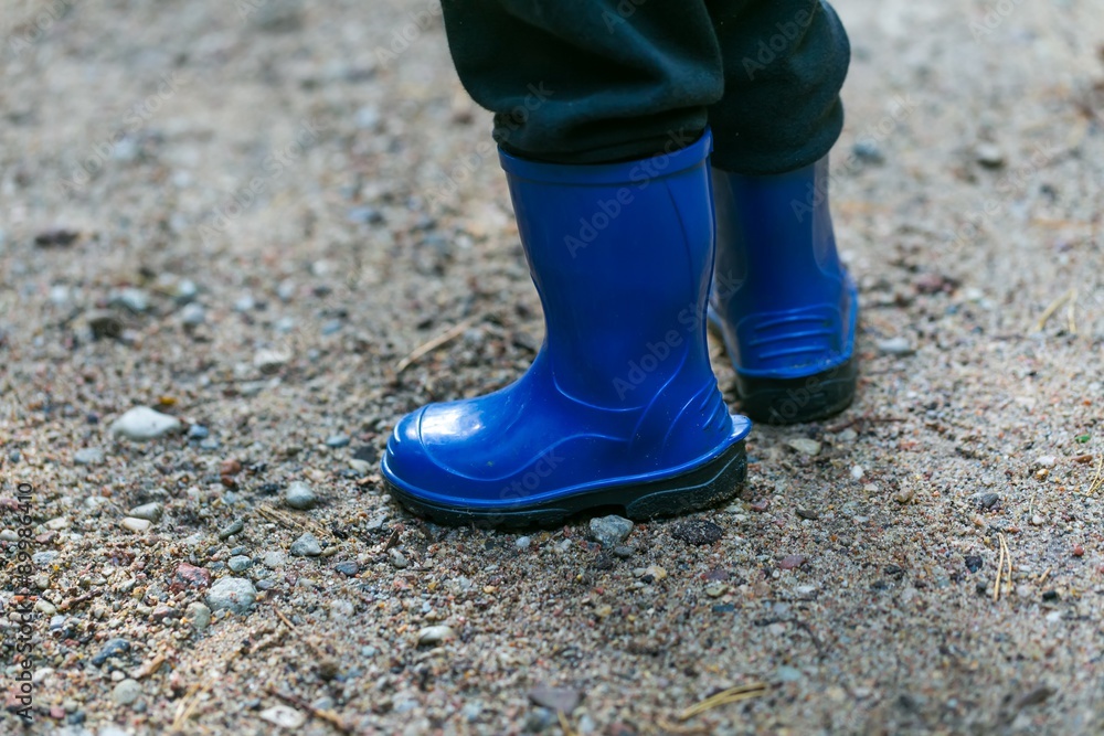 Little child legs in rain boots