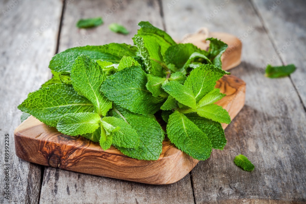 organic fresh bunch of mint on wooden cutting board organic fresh bunch of mint on wooden cutting board