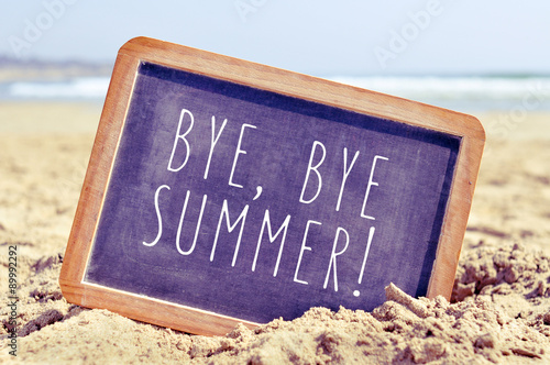 text bye, bye summer in a chalkboard on the beach
