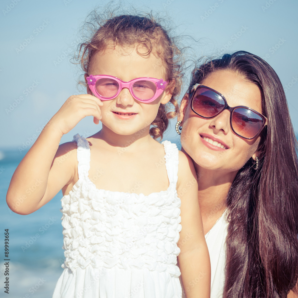 Mother and daughter playing on the beach at the day time. Mother and daughter playing on the beach at the day time.