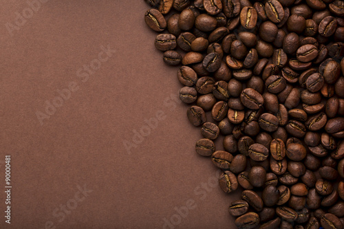 Close up roasted coffee beans on an brown background © ironstealth