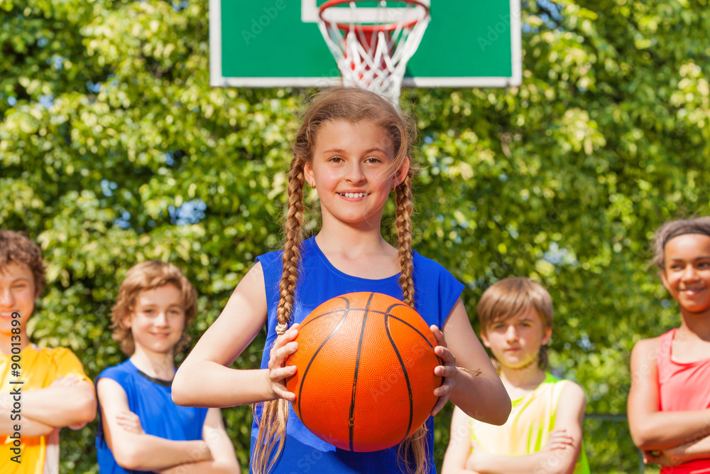 Girl with ball and her team standing behind Girl with ball and her team standing behind
