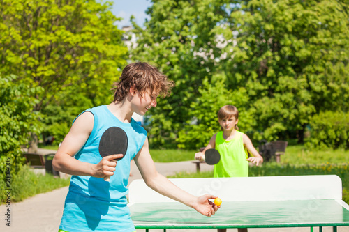 Obraz na płótnie Two boys playing together ping pong outside