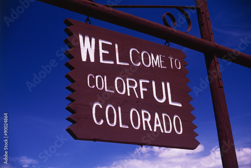 This is a road sign that says, Welcome to Colorful Colorado. It is a brown wood sign, painted with white letters against a blue sky.