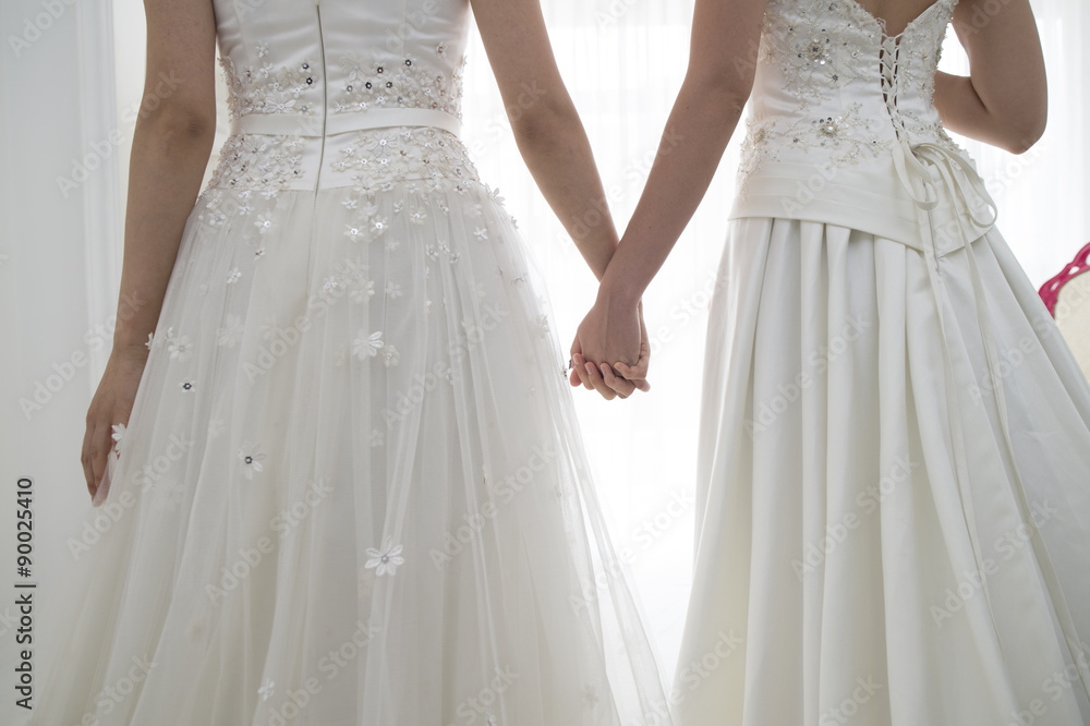From behind of two people of the bride wearing a wedding dress From behind of two people of the bride wearing a wedding dress