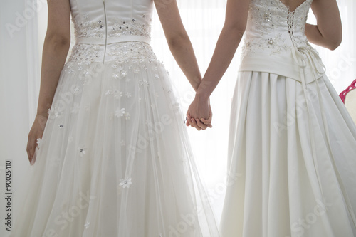 Canvas Print From behind of two people of the bride wearing a wedding dress
