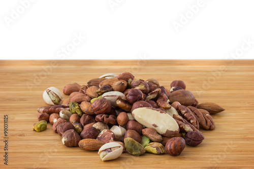 Close-up of mixture of several different peanuts on a wooden table. Copy space.