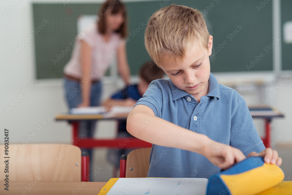 schulkind nimmt stifte aus seiner federmappe schulkind nimmt stifte aus seiner federmappe