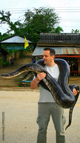 Un homme portant un serpent géant photo