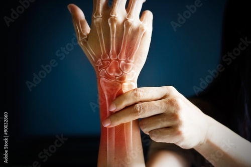 Acute pain in a woman wrist, colored in red on dark blue background