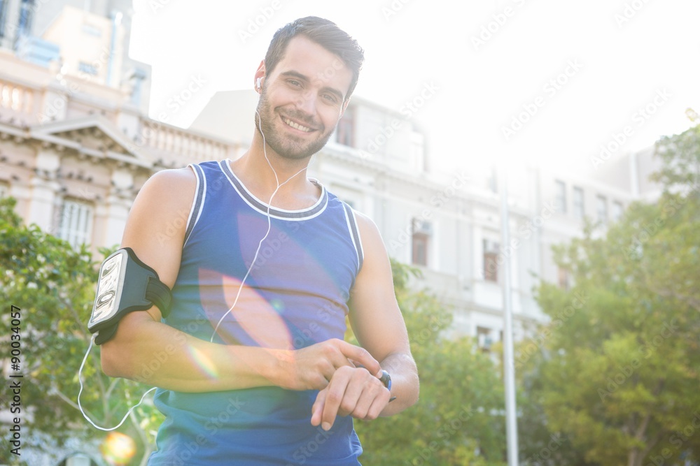 Smiling handsome athlete setting heart rate watch Smiling handsome athlete setting heart rate watch