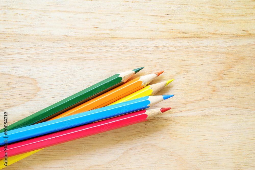 Fototapeta premium Color pencils on wood background