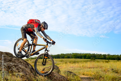 Cyclist Riding the Bike Down Rocky Hill