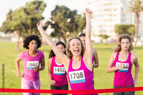 Cheering blonde winning breast cancer marathon © WavebreakmediaMicro