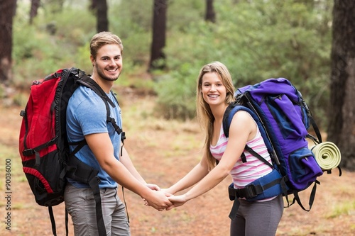 Young happy hiker couple holding hands
