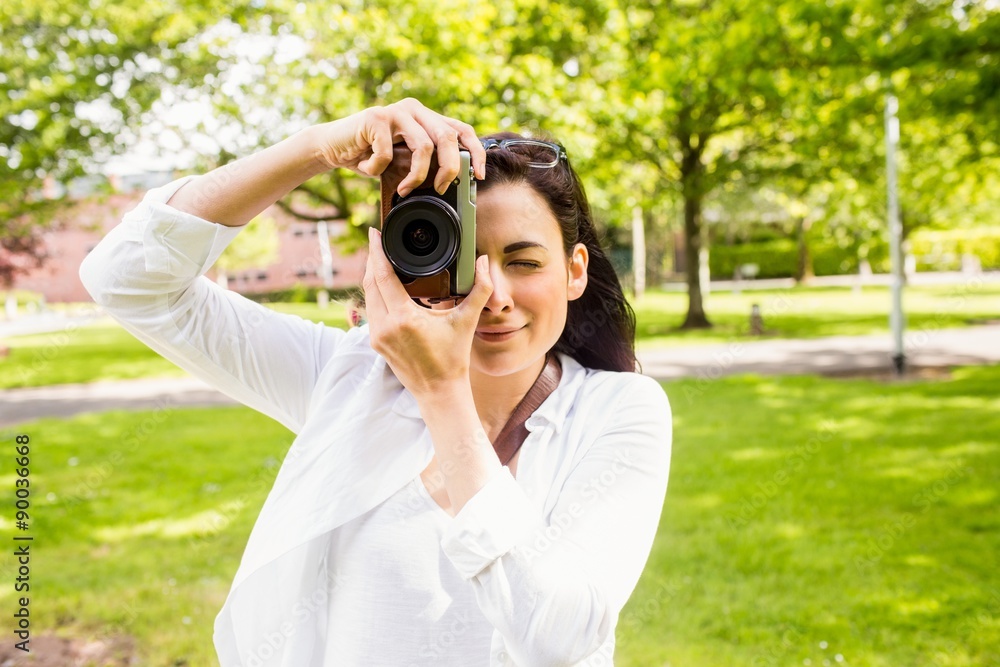Beautiful brunette taking photo in the park Beautiful brunette taking photo in the park