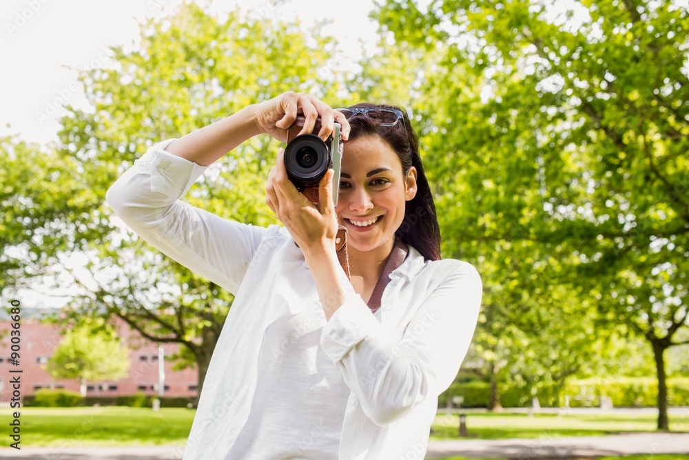 Beautiful brunette taking photo in the park Beautiful brunette taking photo in the park