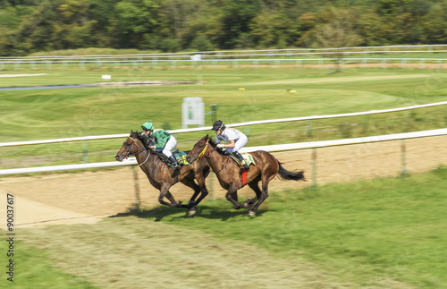 Two girls jockey riding race horse