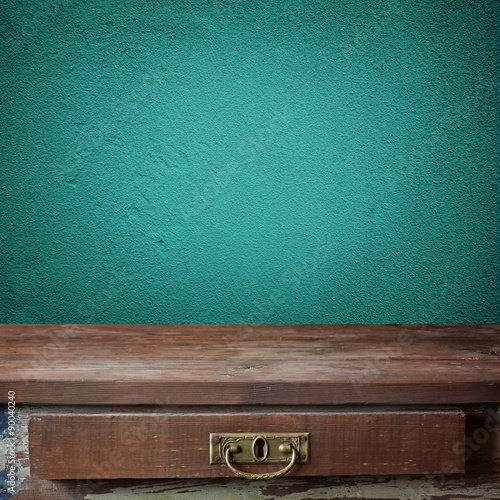 Empty wooden table against a blue wall.