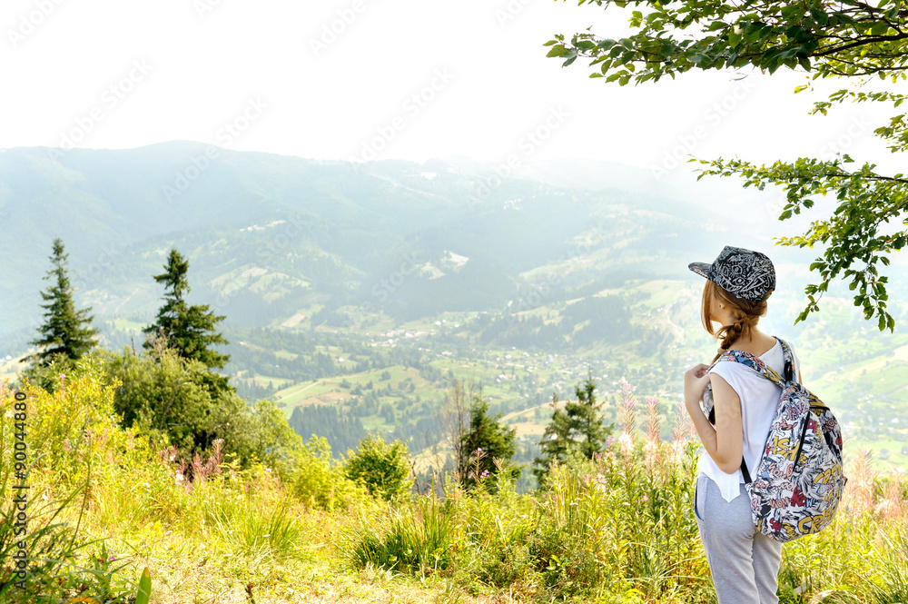 Young girl with backpack in mountain.