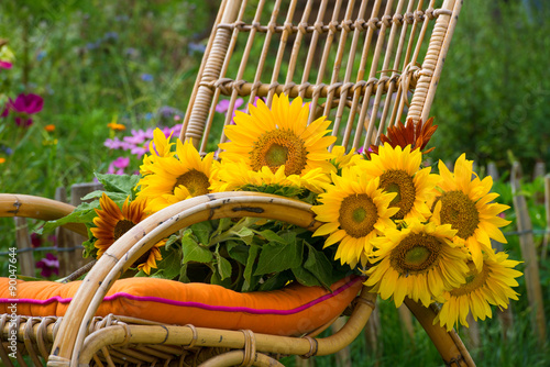 Fototapeta Naklejka Na Ścianę i Meble -  Schaukelstuhl mit Sonnenblumen