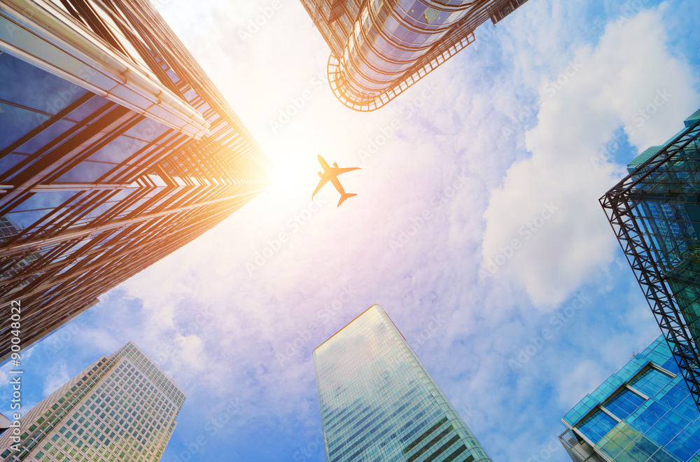 Obraz premium Samolot latający nad nowoczesnych drapaczy chmur biznesu. Transport, podróże.