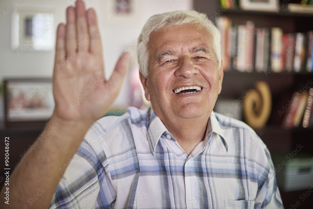 Senior man waving to the camera Senior man waving to the camera