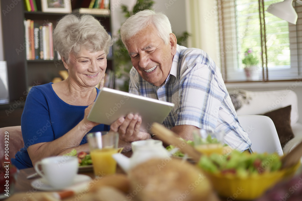 Modern couple of elder people using a touch pad Modern couple of elder people using a touch pad