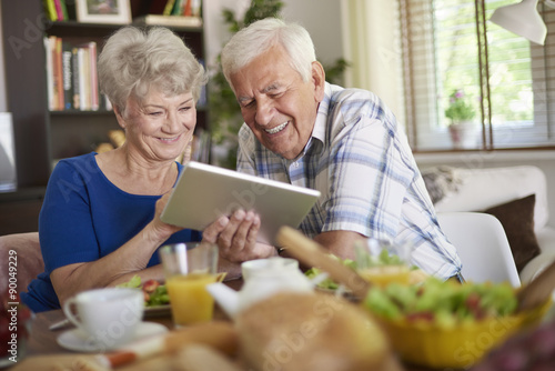 Modern couple of elder people using a touch pad