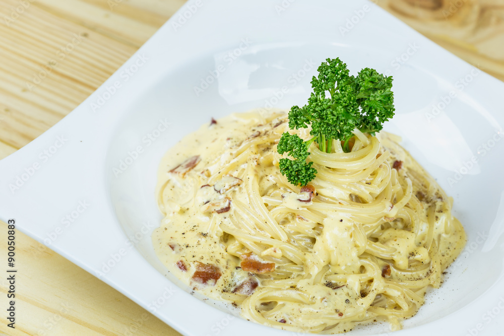 Spaghetti Cabonara with creamy sauce on wooden table Spaghetti Cabonara with creamy sauce on wooden table