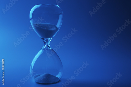 Hourglass on color background