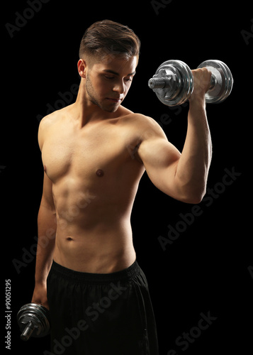 Muscle young man holding du...