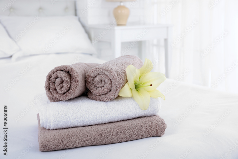 Freshly laundered fluffy towels in bedroom interior Freshly laundered fluffy towels in bedroom interior