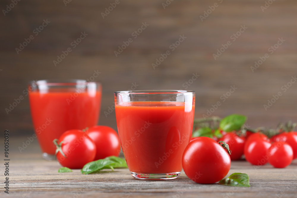 Glasses of tomato juice with vegetables on wooden table close up Glasses of tomato juice with vegetables on wooden table close up