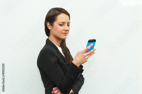 Business woman dialing and stsnding against the glass wall in th photo