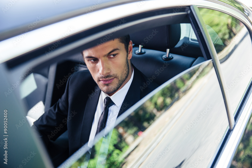 Businessman looking at window in car