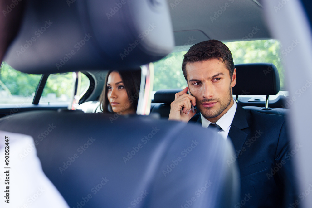 Businessman talking on the phone in car