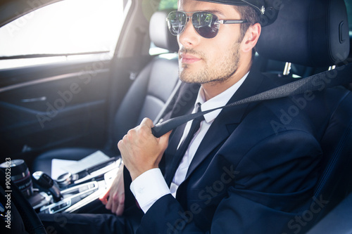Male chauffeur sitting in a car © Drobot Dean