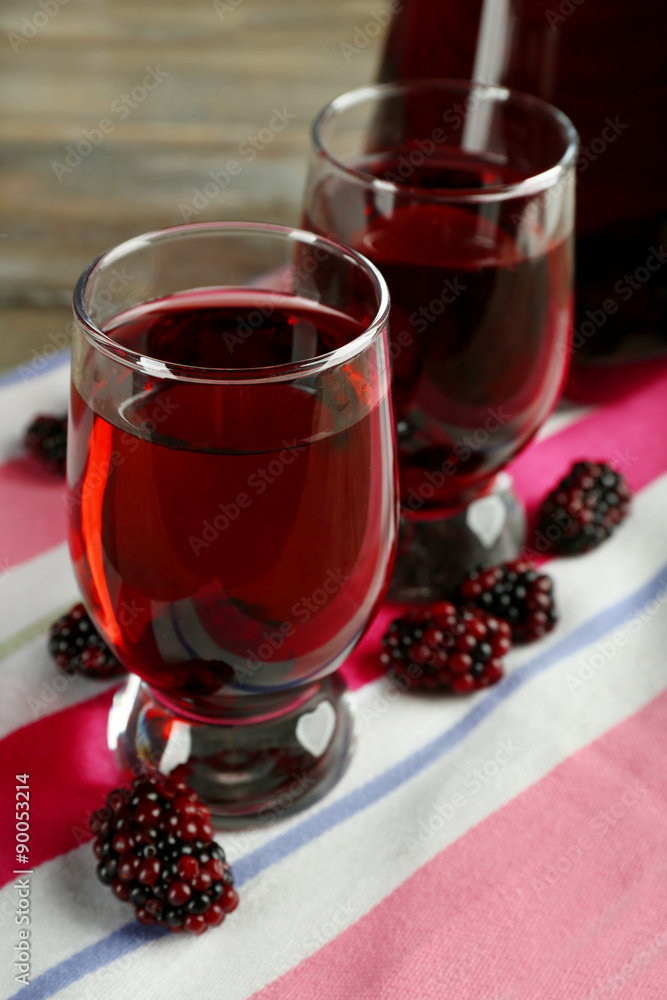 Glasses of blackberry juice on wooden table, closeup Glasses of blackberry juice on wooden table, closeup