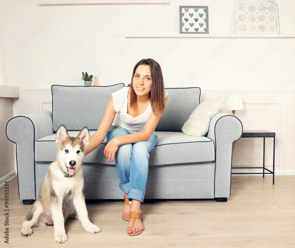 Portrait of young woman and her malamute dog in room Portrait of young woman and her malamute dog in room