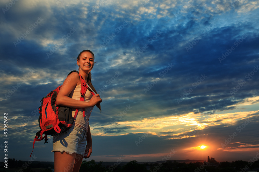 Young woman with red backpack walking on sunset summer. Young woman with red backpack walking on sunset summer.