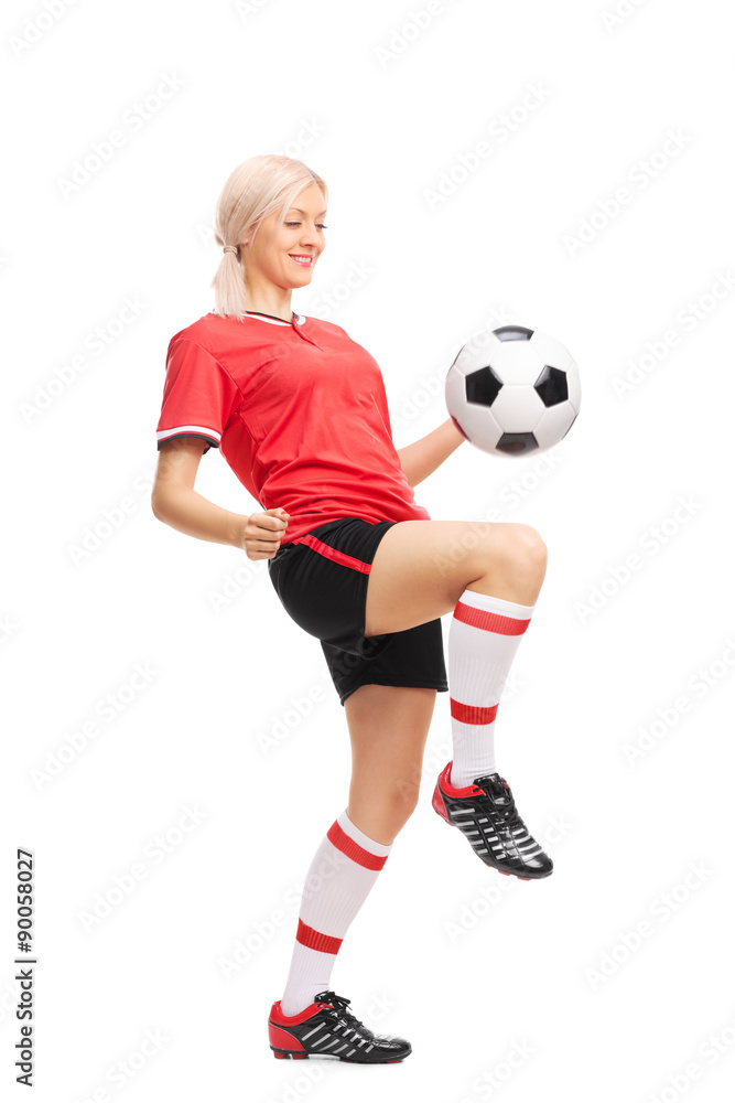 Young female soccer player juggling a ball